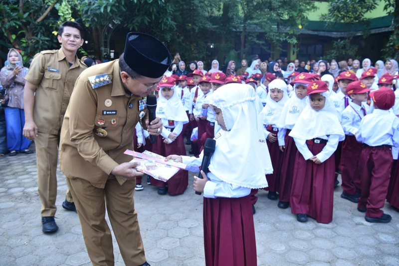 Walikota Jambi Maulana saat memberikan buku kepada siswa SD di Kota Jambi. 